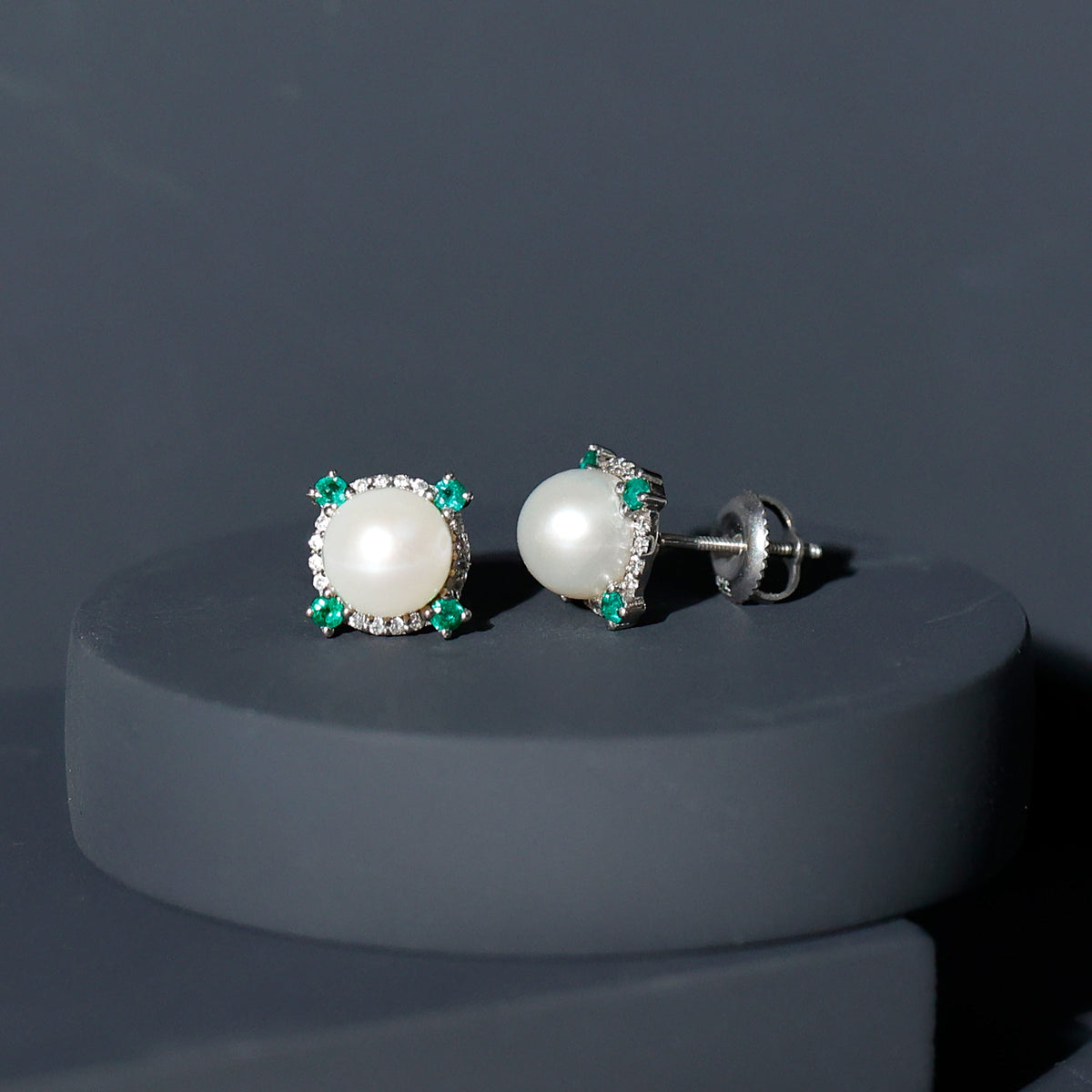 Rosec Jewels 6 Carat freshwater pearl bridal stud earrings with emerald accents, featuring elegant pearl and green gemstone details.
