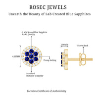 Lab-created blue sapphire flower earrings with diamond halo from Rosec Jewels, featuring intricate floral design and sparkling accents.