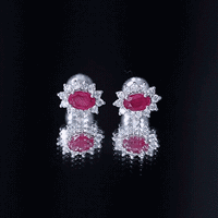 Genuine oval cut ruby and diamond halo stud earrings by Rosec Jewels, featuring a stunning red ruby surrounded by sparkling diamonds.