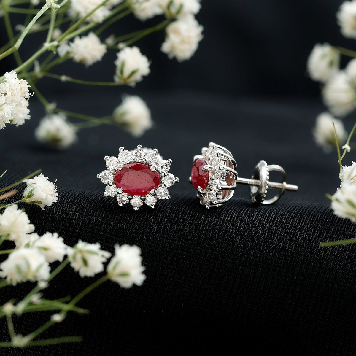 Genuine oval cut ruby and diamond halo stud earrings by Rosec Jewels featuring sparkling gemstones and elegant design.