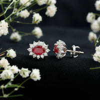 Genuine oval cut ruby and diamond halo stud earrings by Rosec Jewels featuring sparkling gemstones and elegant design.