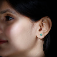 Real emerald stud earrings with diamond halo from Rosec Jewels, featuring vibrant green emeralds and sparkling diamonds.