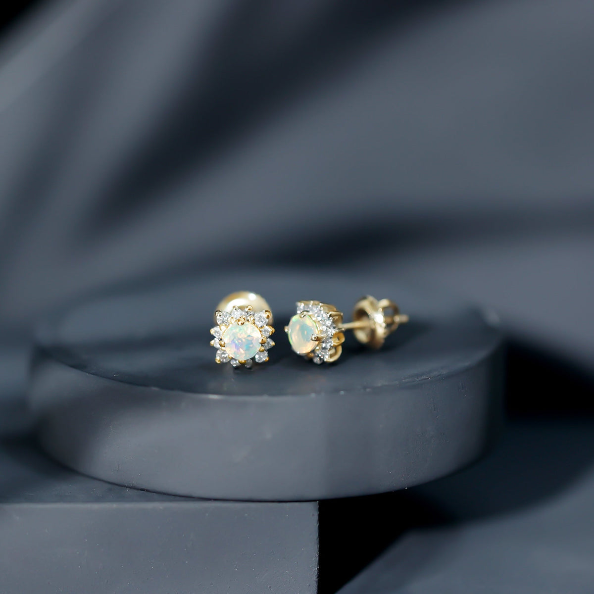 Ethiopian opal stud earrings with diamond halo from Rosec Jewels, featuring vibrant opal gemstones and sparkling diamond accents.