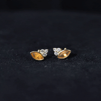 Marquise cut fire opal stud earrings with diamond trio accents by Rosec Jewels, showcasing vibrant orange gemstones and sparkling diamonds.