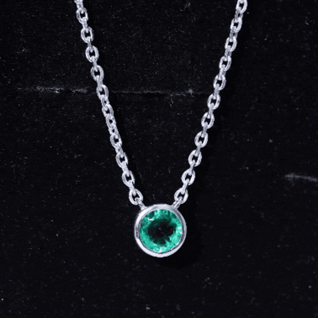 Bezel set lab-grown emerald solitaire pendant with silver chain from Rosec Jewels, showcasing a vibrant green emerald gemstone.