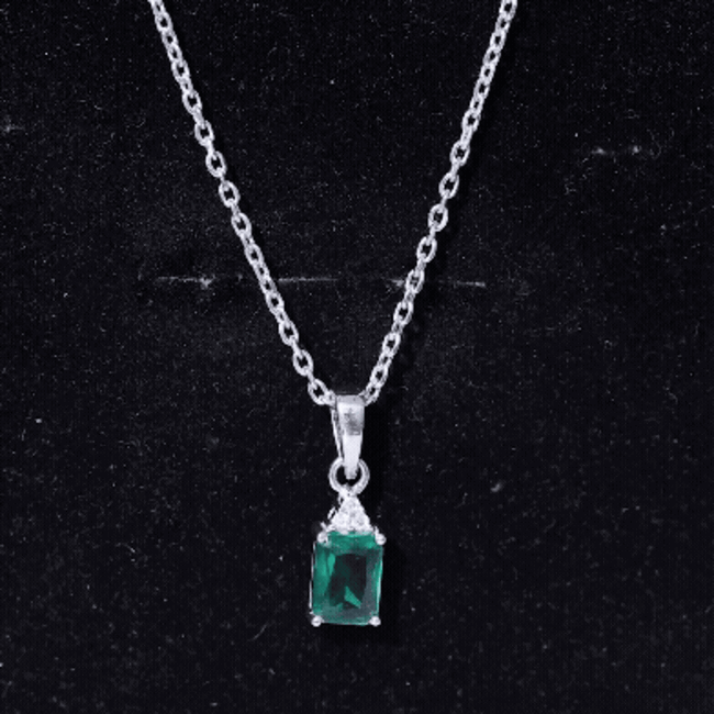 Emerald cut lab-grown emerald solitaire pendant necklace with silver chain, featuring a 1.68 carat gemstone and elegant design.