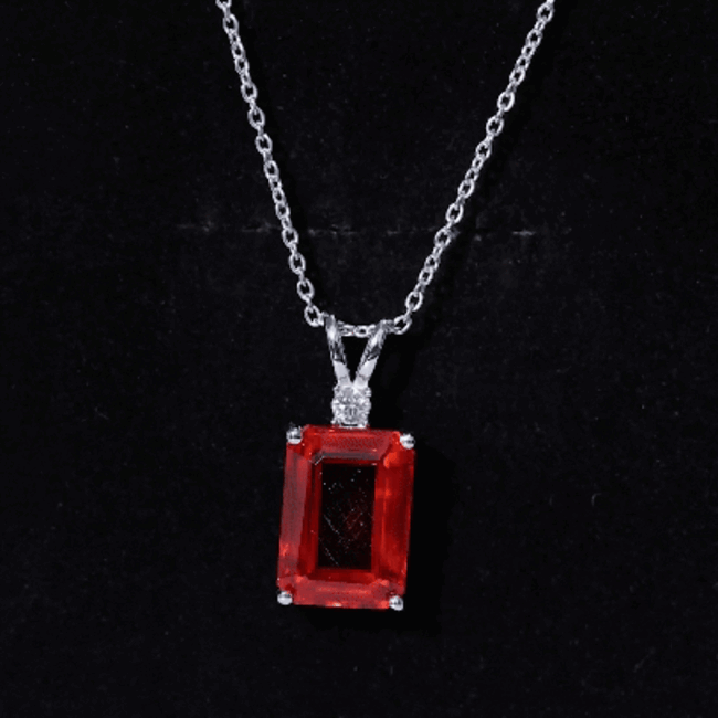 Lab grown orange sapphire pendant with emerald cut, set on a silver chain from Rosec Jewels.