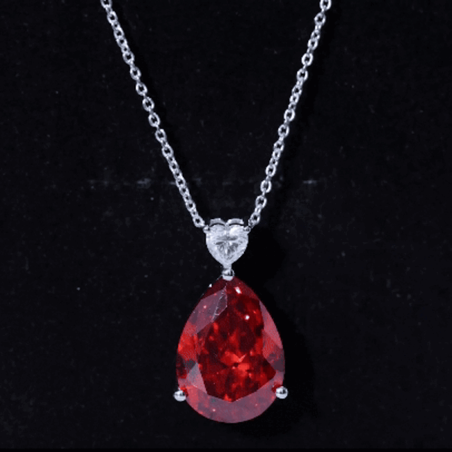 Pear-shaped lab-grown orange sapphire pendant with silver chain from Rosec Jewels, featuring a teardrop design and elegant silver setting.