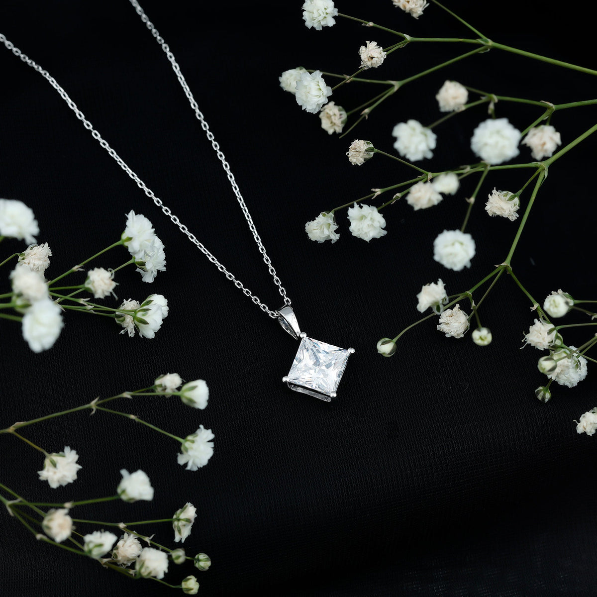 Diagonal set of three 3-carat cubic zirconia princess cut pendants with chain by Rosec Jewels displayed on a white background.