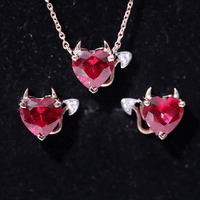 Lab grown ruby heart necklace and earrings set with diamonds from Rosec Jewels, featuring white gemstone accents and elegant design.