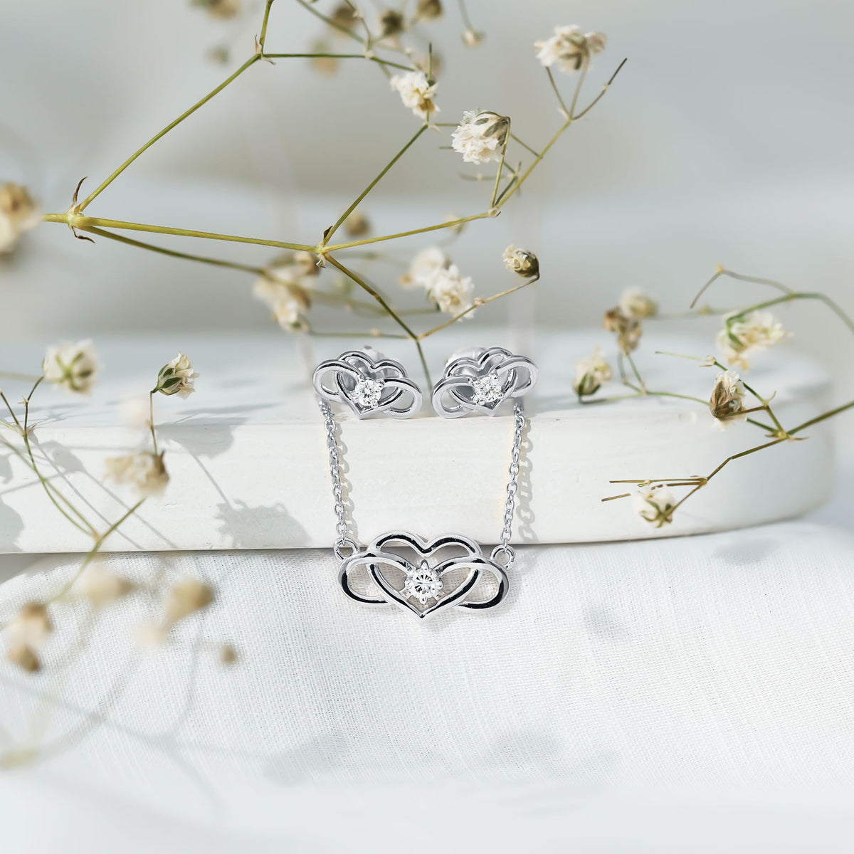 Round cut diamond infinity heart jewelry set by Rosec Jewels featuring elegant design with sparkling diamonds and intricate heart details.
