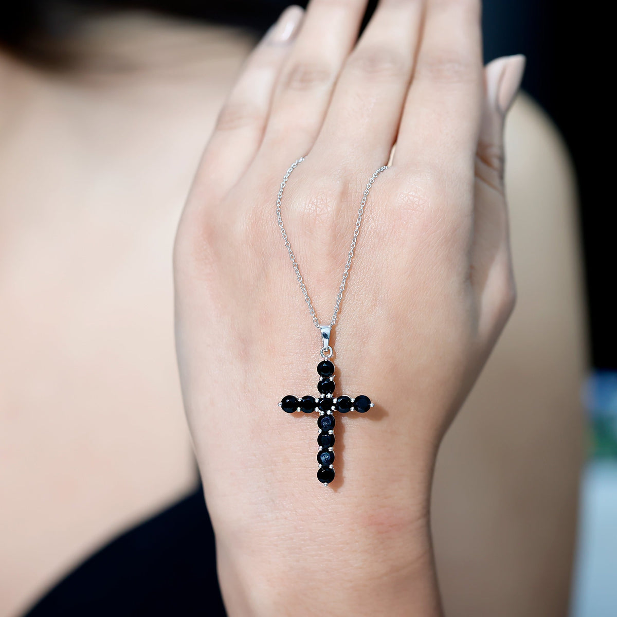 Natural black onyx cross pendant necklace for women with silver chain, featuring a polished black onyx stone.