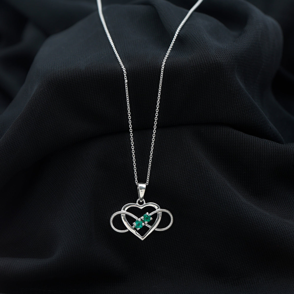 Heart infinity pendant necklace by Rosec Jewels featuring a real emerald gemstone and intricate silver design.