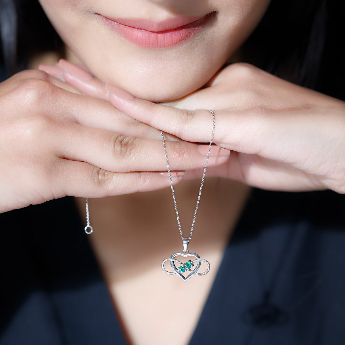 Heart infinity pendant necklace with real emerald from Rosec Jewels, featuring a silver chain and intricate pendant design.