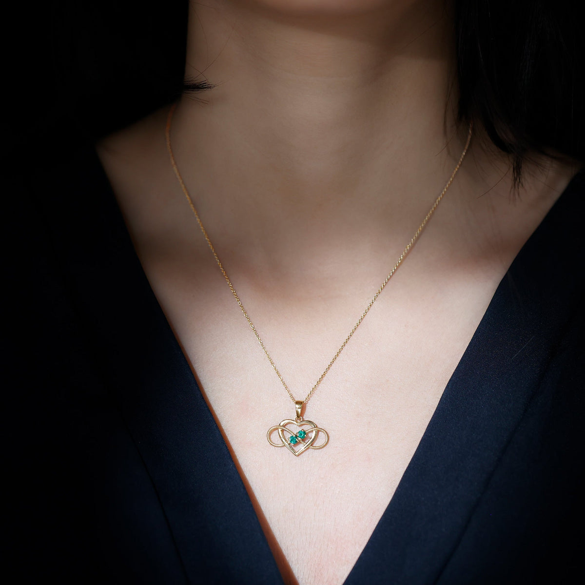 Heart infinity pendant with real emerald from Rosec Jewels featuring a silver chain and detailed heart and infinity design.