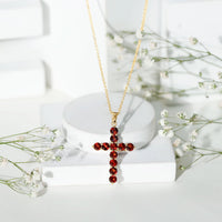Genuine garnet cross pendant necklace by Rosec Jewels featuring a red garnet gemstone on a silver chain.