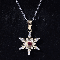 Lab created ruby snowflake pendant with diamond accents, showcasing a detailed snowflake design in a jewelry pendant.