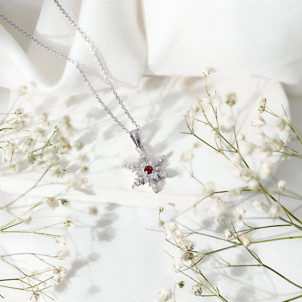 Lab-created ruby snowflake pendant with diamond accents from Rosec Jewels, featuring a detailed snowflake design.