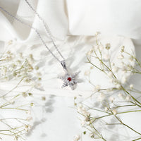Lab-created ruby snowflake pendant with diamond accents from Rosec Jewels, featuring a detailed snowflake design.