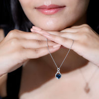 Heart-shaped London Blue Topaz infinity pendant with diamonds, elegant jewelry piece by Rosec Jewels.