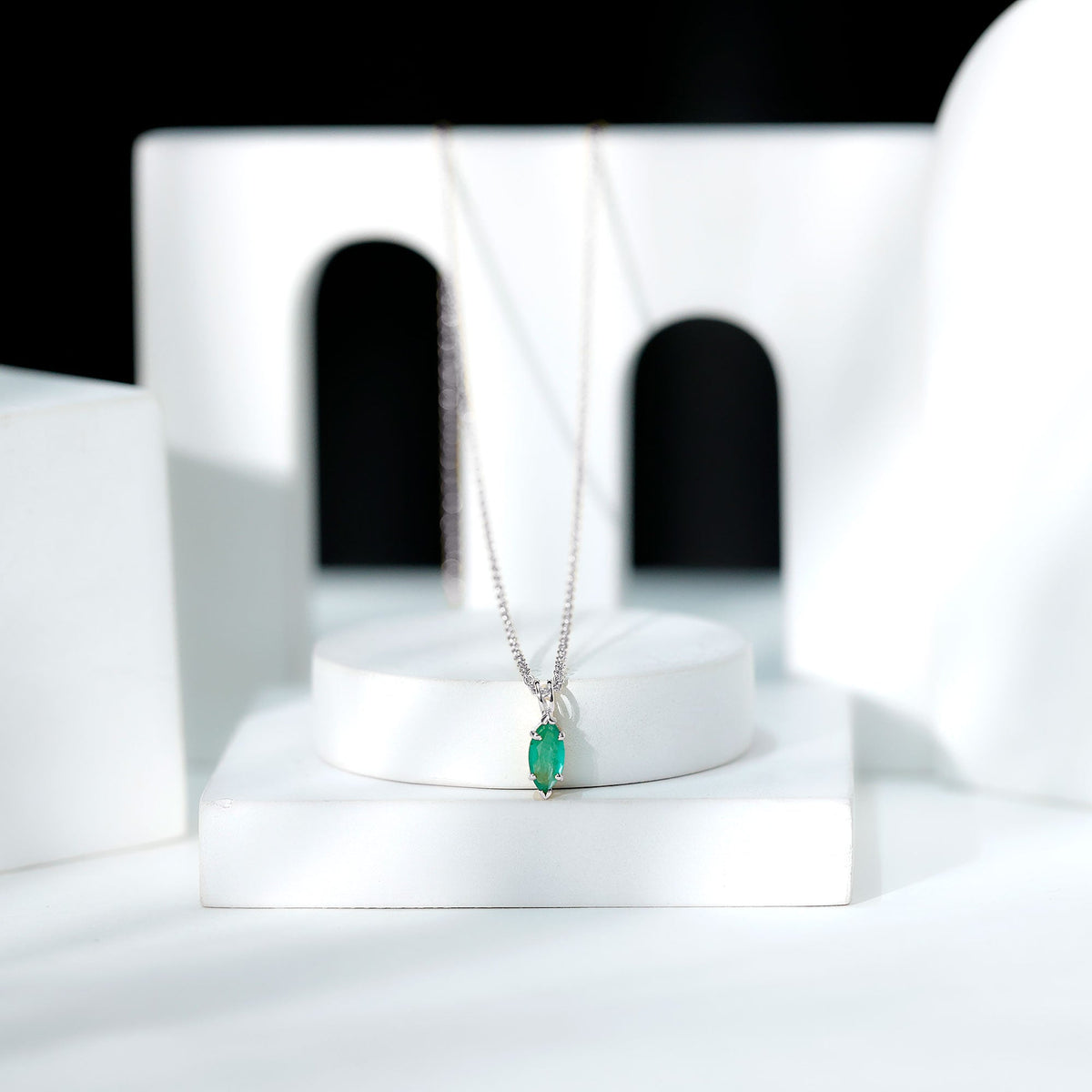 Marquise cut emerald solitaire pendant necklace by Rosec Jewels with a delicate gold chain and elegant gemstone setting.