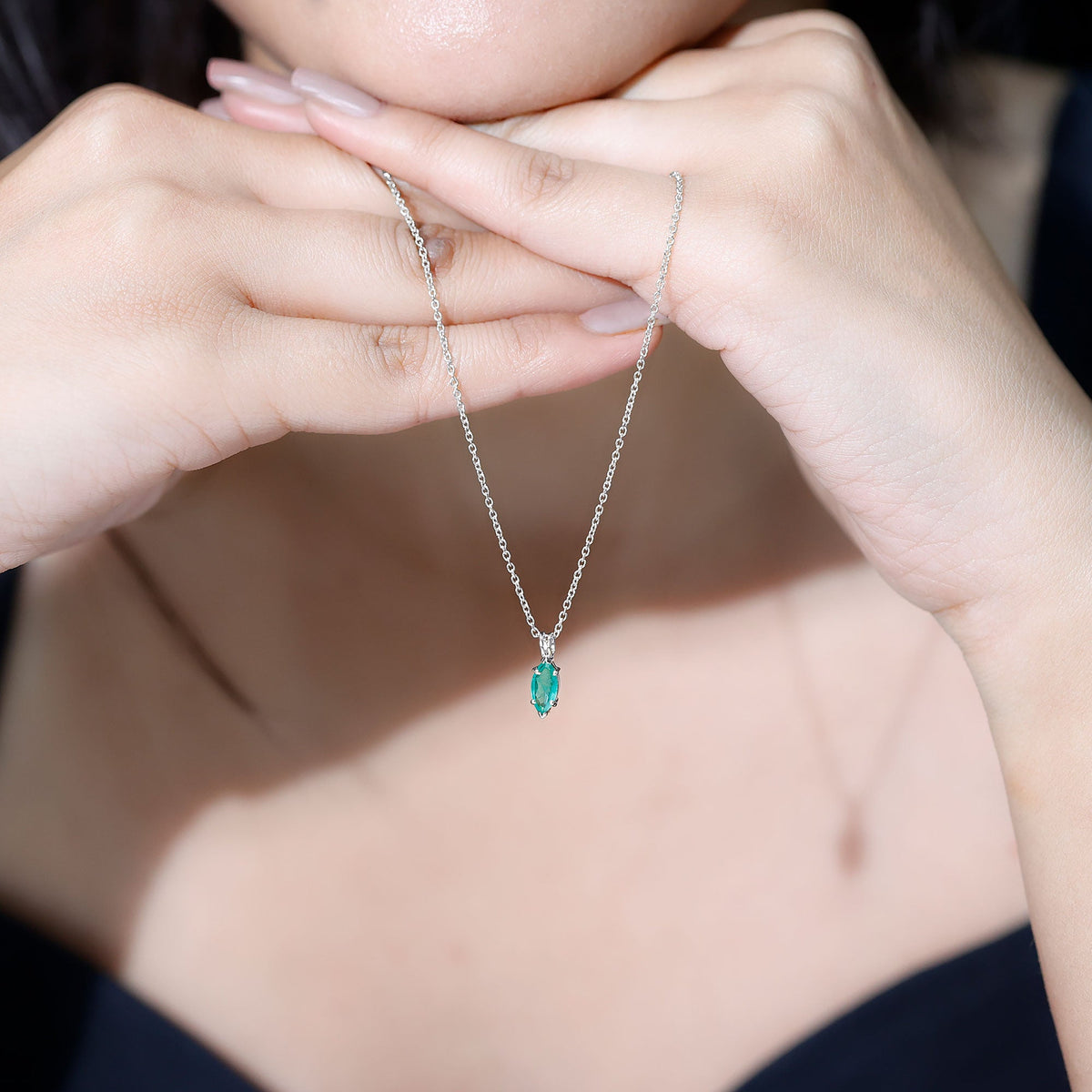 Marquise cut emerald solitaire pendant necklace by Rosec Jewels featuring a central green emerald gemstone and a delicate chain.