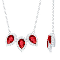 Pear cut lab-created ruby three-stone necklace with moissanite halo pendant from Rosec Jewels, featuring a sparkling gemstone design.