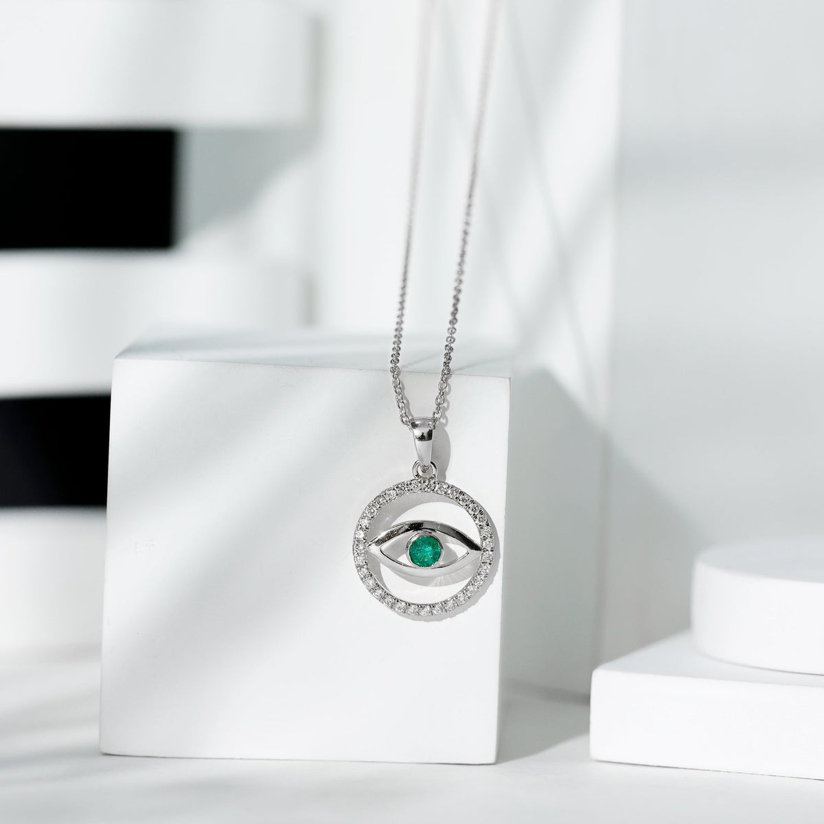 Real emerald and diamond evil eye pendant necklace by Rosec Jewels featuring a vibrant green emerald and sparkling diamonds.