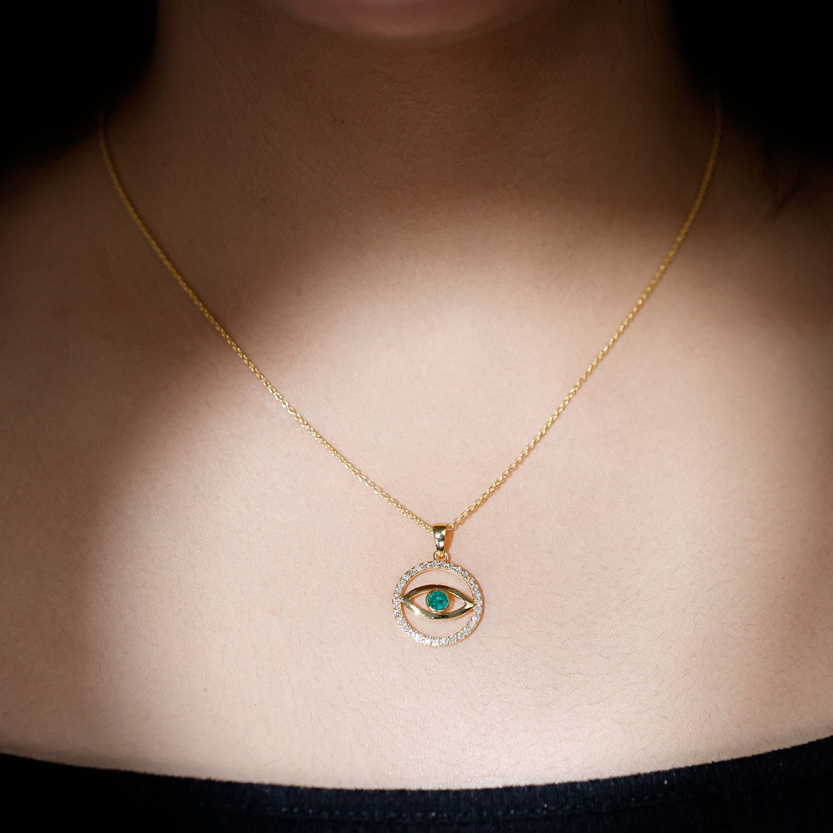 Real emerald and diamond evil eye pendant necklace from Rosec Jewels featuring a detailed silver pendant with vibrant green and sparkling stones.