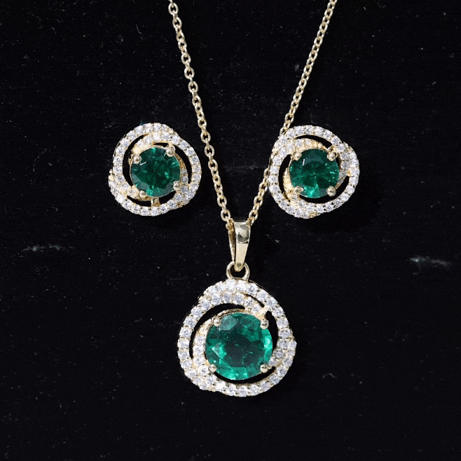 Lab-created emerald swirl necklace and earrings set with moissanite, featuring vibrant green gemstones and elegant jewelry design.