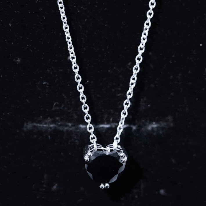 Heart-shaped black spinel solitaire pendant in a double prong setting, featuring a 2-carat black gemstone on a silver chain.