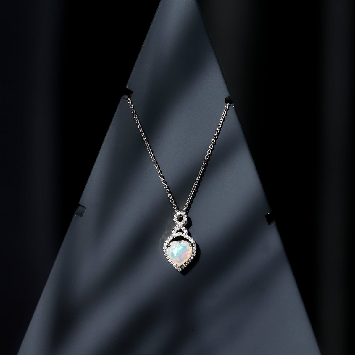 Heart-shaped Ethiopian opal infinity pendant with diamonds, featuring a 2-carat gemstone, crafted by Rosec Jewels.