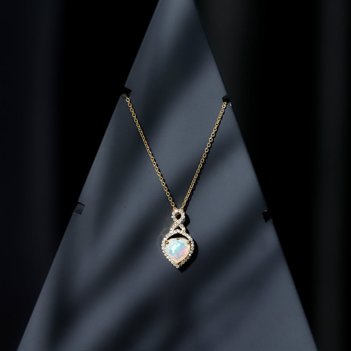 Heart-shaped Ethiopian opal infinity pendant with diamonds, featuring a 2-carat center stone, by Rosec Jewels.
