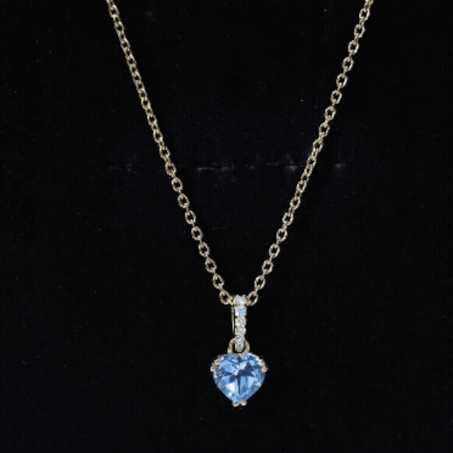 Yellow gold heart pendant featuring a 0.9 carat Swiss Blue Topaz solitaire and diamond accents on a chain.
