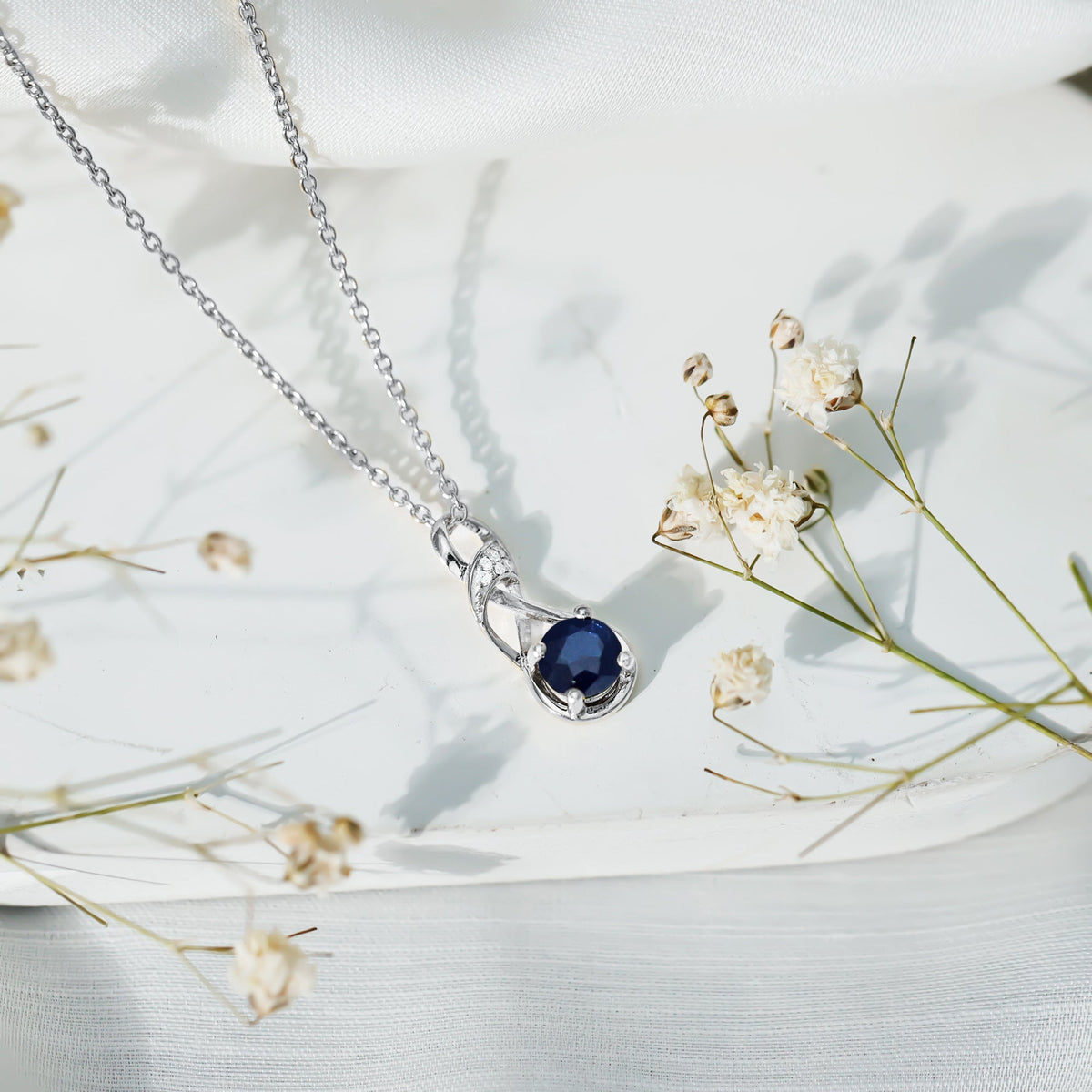 Natural 1 Carat Blue Sapphire Infinity Necklace pendant with silver chain from Rosec Jewels, showcasing a sparkling blue sapphire infinity design.
