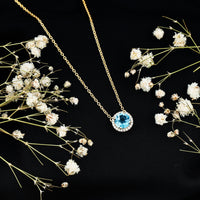 Natural 1.5 carat Swiss Blue Topaz pendant necklace with diamond halo, featuring a delicate chain and elegant design from Rosec Jewels.