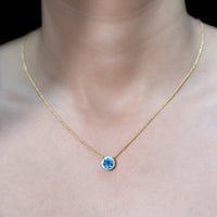 Natural 1.5 carat Swiss Blue Topaz pendant with diamond halo on a delicate chain, jewelry by Rosec Jewels.