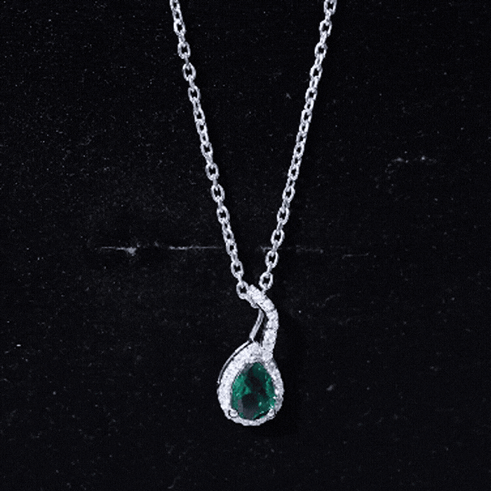 Lab grown emerald and moissanite teardrop pendant necklace with chain, featuring a 0.7 carat gemstone set in elegant jewelry.