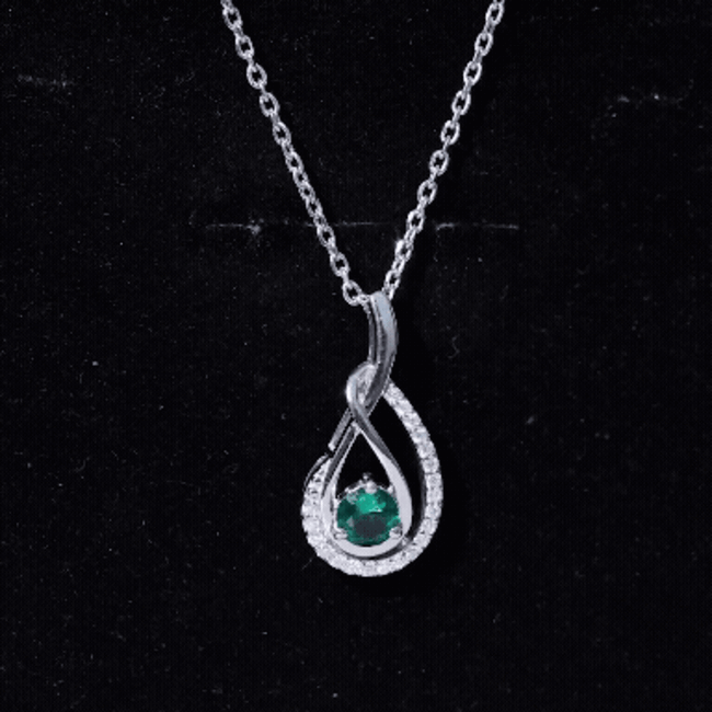 Lab grown emerald and moissanite teardrop pendant in silver, featuring a sparkling gemstone necklace with elegant design.