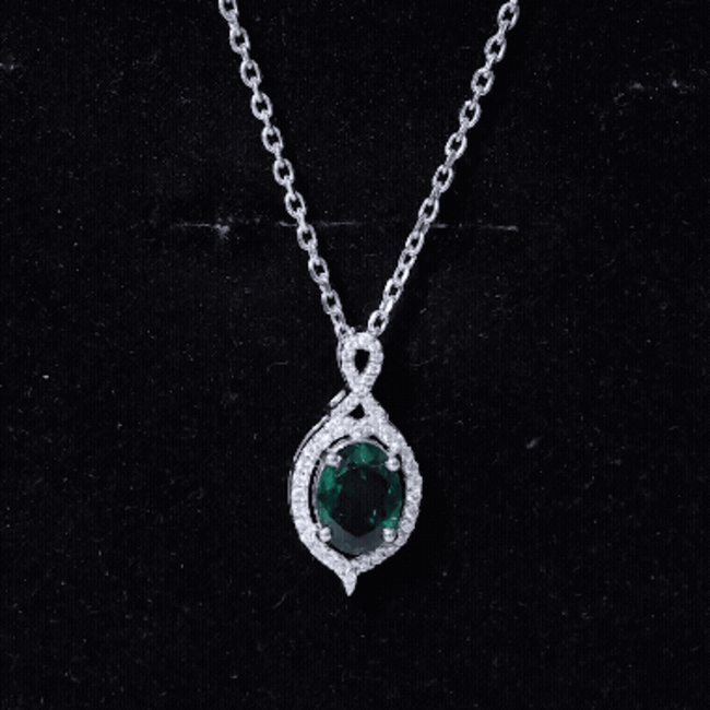 Oval cut lab-grown emerald pendant with vintage design in silver, featuring a 1.2 carat gemstone on a delicate chain.