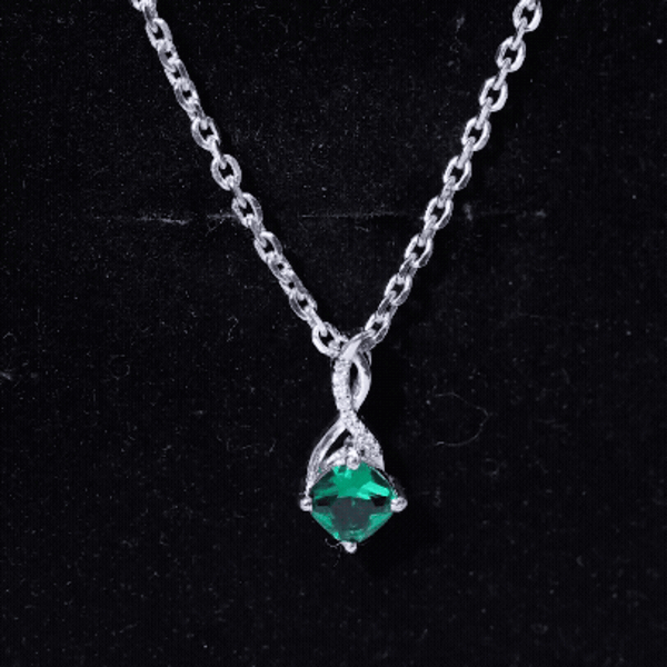 Cushion cut lab-created emerald infinity pendant on silver chain by Rosec Jewels, featuring a 0.9 carat gemstone.