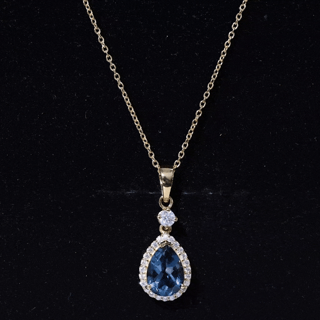 London Blue Topaz teardrop pendant with moissanite halo, featuring a silver chain, from Rosec Jewels.