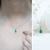 Pear cut emerald solitaire pendant with diamond accent bail by Rosec Jewels, featuring a green emerald gemstone and elegant silver setting.