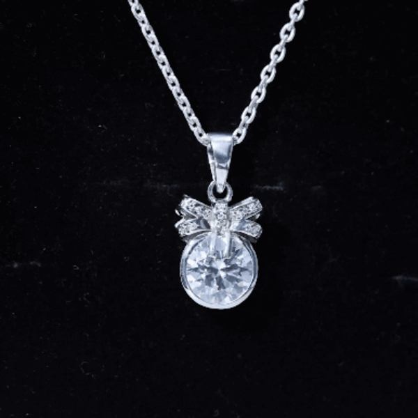 Bezel set 2 carat moissanite pendant with bow design by Rosec Jewels, featuring a sparkling white gemstone and delicate craftsmanship.