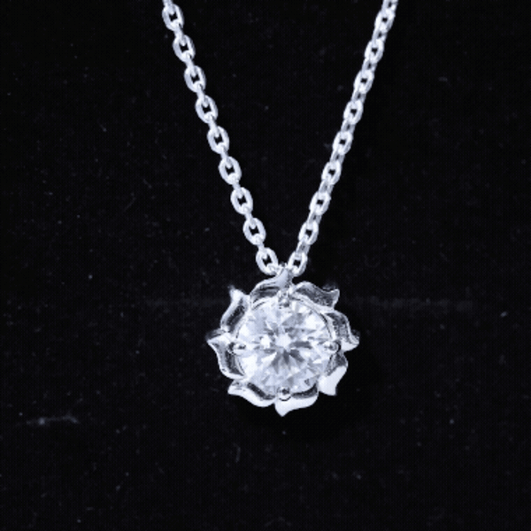 Two-carat solitaire moissanite flower pendant with silver chain, featuring sparkling gemstone and delicate floral design.