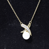 Yellow gold pendant necklace featuring a freshwater pearl and diamond XO design by Rosec Jewels.