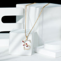 Lab-grown ruby and diamond pendant necklace with letter S from Rosec Jewels, featuring a sparkling gemstone pendant on a chain.