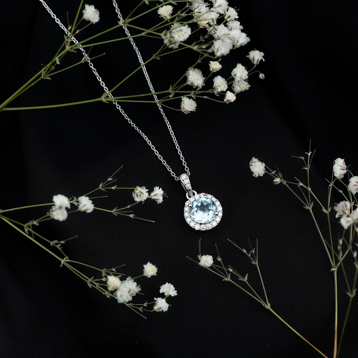 Round cut 2 carat sky blue topaz pendant necklace with silver chain, showcasing a sparkling blue gemstone on a sleek silver pendant.