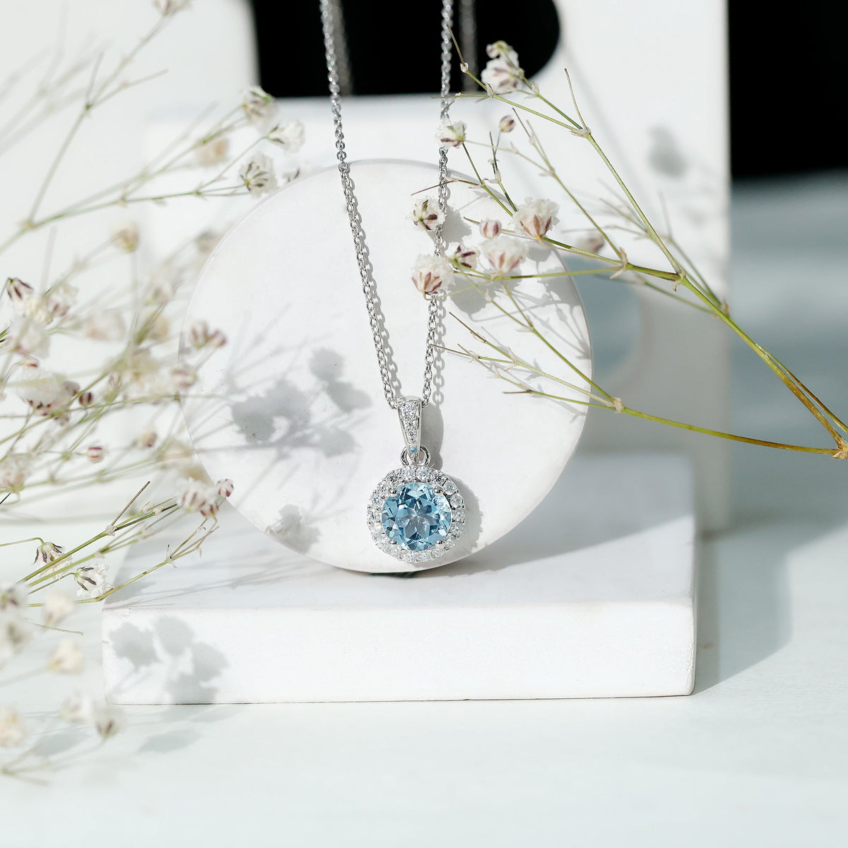 Round cut 2 carat sky blue topaz pendant necklace with silver chain, showcasing a sparkling blue gemstone and elegant jewelry design