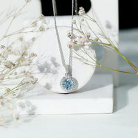 Round cut 2 carat sky blue topaz pendant necklace with silver chain, showcasing a sparkling blue gemstone and elegant jewelry design